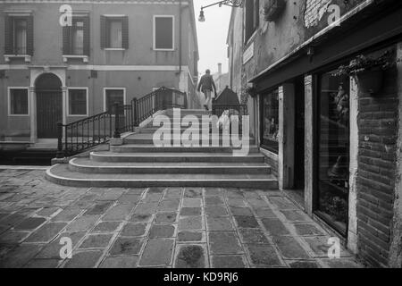 Venedig, Italien. 11. Oktober, 2017. (Bilder in Schwarz und Weiß) ein Mann die Brücke in einer nebligen Tag in Venedig, Italien. In diesem Zeitraum in Venedig beginnt der erste neblige Morgen. © Simone padovani/Erwachen/alamy leben Nachrichten Stockfoto