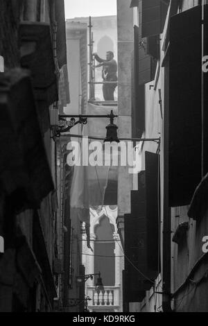 Venedig, Italien. 11. Oktober, 2017. (Bilder in Schwarz und Weiß) ein Arbeiter Reparaturen eine Wand in einer nebligen Tag in Venedig, Italien. In diesem Zeitraum in Venedig beginnt der erste neblige Morgen. © Simone padovani/Erwachen/alamy leben Nachrichten Stockfoto