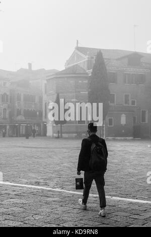 Venedig, Italien. 11. Oktober, 2017. (Bilder in Schwarz und Weiß) ein Mann in San Polo Platz in einer nebligen Morgen in Venedig, Italien. In diesem Zeitraum in Venedig beginnt der erste neblige Morgen. © Simone padovani/Erwachen/alamy leben Nachrichten Stockfoto