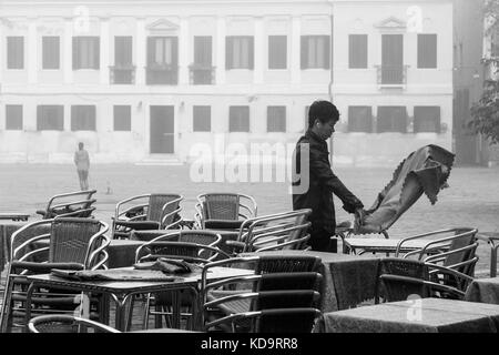 Venedig, Italien. 11. Oktober, 2017. (Bilder in Schwarz und Weiß) ein Arbeitnehmer stellt die außerhalb von Tabellen in einer nebligen Tag in Venedig, Italien. In diesem Zeitraum in Venedig beginnt der erste neblige Morgen. © Simone padovani/Erwachen/alamy leben Nachrichten Stockfoto