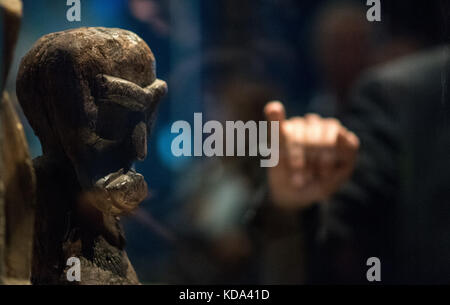 Stuttgart, Deutschland. Oktober 2017. Ein Mann, der auf eine Holzfigur aus dem frühen 19. Jahrhundert hinweist, während einer Presseführung durch die Ausstellung „Hawai'i – Königliche Insel im Pazifik“ im Lindenmuseum Stuttgart, 12. Oktober 2017. Die Sonderausstellung des Landes Baden-Württemberg thematisiert Kunst und Kultur sowie Vergangenheit und Gegenwart der hawaiianischen Inseln. Die Ausstellung wird vom 14. Oktober 2017 bis zum 13. Mai 2018 eröffnet. Quelle: Sebastian Gollnow/dpa/Alamy Live News Stockfoto