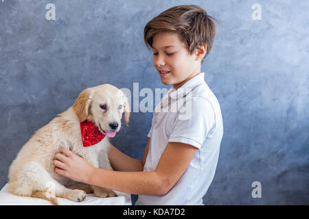 Portrait von jugendlich Junge mit Golden Retriever von der Wand Stockfoto