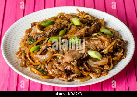 Im chinesischen Stil hoisin Ente Nudeln mit Pak Choi gegen eine rosa Holz- Hintergrund Stockfoto