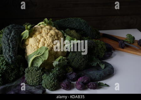 Noch immer leben von verschiedenen Arten von Kohl auf dem Tisch: lacinato Kale, blau geringelt vates Grünkohl, Blumenkohl, Rosenkohl ende Brokkoli. Stockfoto