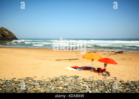 Sonnenschirme am Strand im Sand an den Strand Praia do Vale Dos Homens in der Nähe von Aljezur, Algarve Portugal Stockfoto