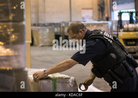 US-Zollbeamte und Grenzschutzbeamte prüfen eingehende Sendungen auf Schmuggelware in der Frachteinrichtung des Boston Logan International Airport am 20. Juni 2017 in Boston, Massachusetts. Stockfoto