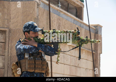 Eine irakische Bundespolizei Sniper schaut durch den Umfang der sein Gewehr auf dem Dach eines Patrol Base Juni 29, 2017 in Mosul, Irak. Eine Kombination zwischen US-amerikanischen und Irakischen Streitkräften im Bereich isis Extremisten zu besiegen. Stockfoto