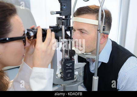 Junge weibliche Augenarzt und männlichen Patienten Sehvermögen prüfen Stockfoto