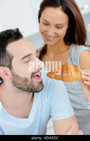 Romantisches Paar teilen ein Croissant Stockfoto