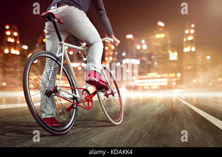 Moderne Fahrrad vor einem nächtlichen Skyline Stockfoto