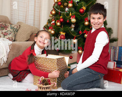 Kind in Santa hat Spaß und Spielen, Geschenke, Weihnachten Dekoration zu Hause, glücklich, Emotion, Winterurlaub Konzept Stockfoto