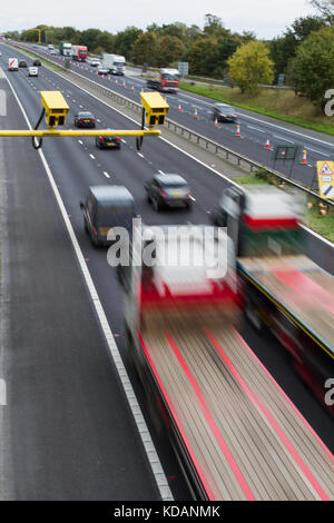 Leuchtend gelbe Blitzer in einer durchschnittlichen Geschwindigkeit prüfen mit Verkehr fließt durch eine Baustellen Bereich auf einem britischen Autobahn oder Schnellstraße. Stockfoto