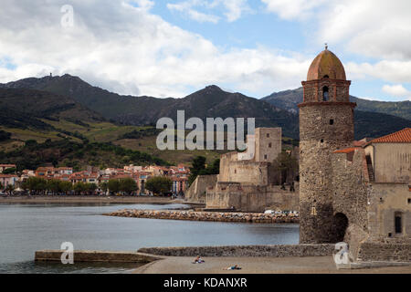 Die mittelalterlichen Leuchtturm in der Eglise Notre Dame des Anges incorporated Collioure, mit dem Château Royal und die Berge im Hintergrund Stockfoto