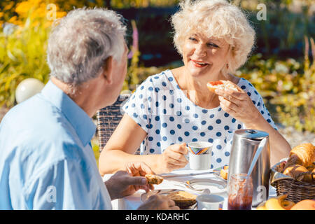 Gerne ältere Paare essen Frühstück in Ihrem Garten draußen Ich Stockfoto