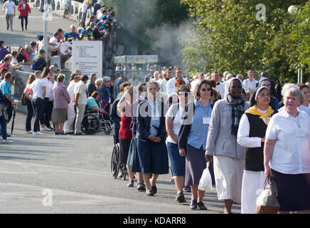 Prozession der Pilger und Priester in Lourdes, Frankreich Stockfoto