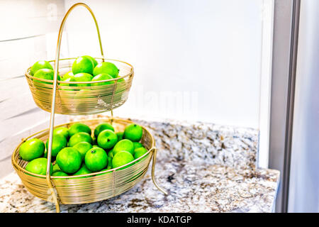 Makro Nahaufnahme des goldenen Tablett mit Schalen von ganzen fake Limes in der Küche in der Inszenierung Modell Haus oder Wohnung Stockfoto