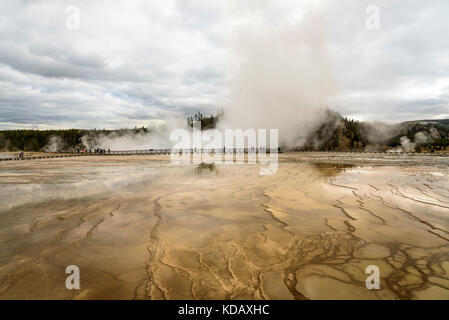 Nicht identifizierbare Menschen hetzen die Grand Prismatic Spring im Yellowstone National Park an einem bewölkten Tag zu sehen Stockfoto