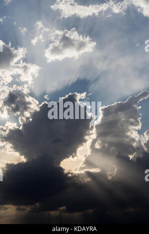 Leistungsstarke Sonnenstrahlen, die sich durch einige Wolken Stockfoto