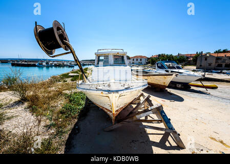 Reparatur und Restauration von alten hölzernen Angeln Schiff oder Boot. alte verwitterte Fischerboot montiert auf Holz- Buchsen für Dry Dock Renovierung und Reparatur mit Stockfoto