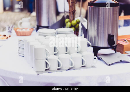 Kaffee, Tassen auf Catering Tabelle auf einer Tagung oder Hochzeit. Gruppe von Leer weißer Keramik Becher für Kaffee oder Tee in außerhalb der Buffet im Geschäft Stockfoto