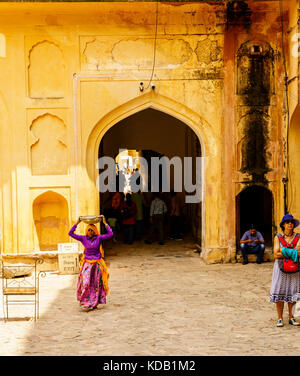 Ein Indien Frau, die eine Pfanne auf den Kopf an einem Palast in Jaipur, Indien Stockfoto