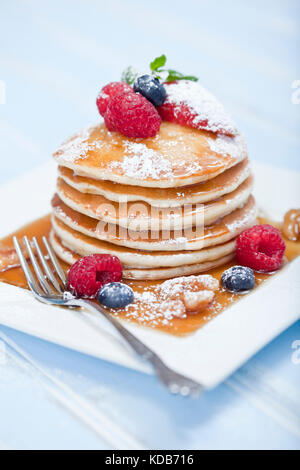 Stapel Pfannkuchen mit gemischten Beeren und Ahornsirup Stockfoto