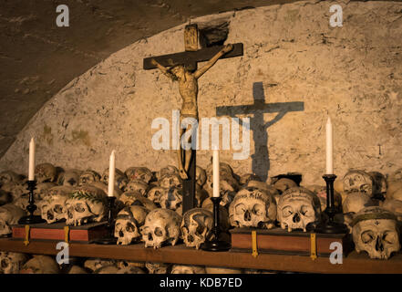 Bemalte Schädel mit Namen, Kerzen und Kreuz (Hallstatt, Österreich) Stockfoto