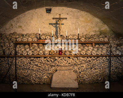 Bemalte Schädel mit Namen, Kerzen und Kreuz (Hallstatt, Österreich) Stockfoto