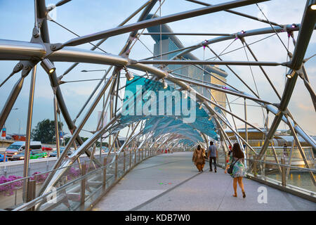 Singapur - Jan 13, 2017: Helix Bridge und Marina Bay Sands Resort in der Dämmerung in Singapur. Marina Bay als der weltweit teuersten Standalone casin Stockfoto