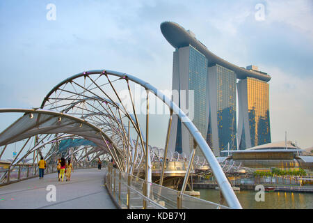 Singapur - Jan 13, 2017: Helix Bridge und Marina Bay Sands Resort in der Dämmerung in Singapur. Marina Bay als der weltweit teuersten Standalone casin Stockfoto