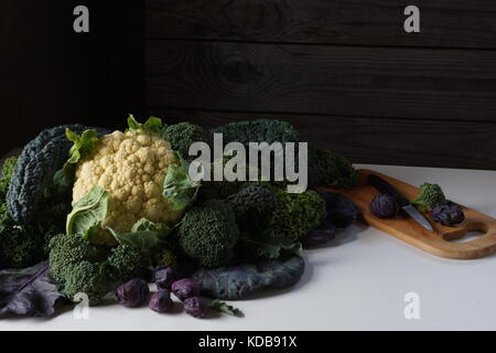 Noch immer leben von verschiedenen Arten von Kohl auf dem Tisch: lacinato Kale, blau geringelt vates Grünkohl, Blumenkohl, Rosenkohl ende Brokkoli. Stockfoto