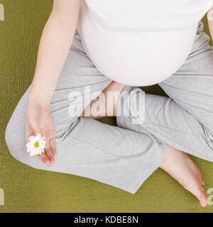Blick von oben auf die schwangere Frau mit Blume Stockfoto