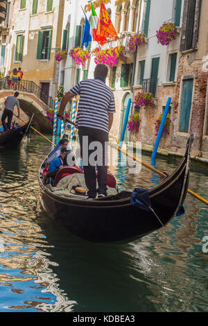 Gondoleer Touristen, die auf der Calle del Remedio, Venedig, Italien Stockfoto