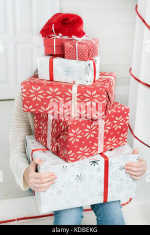 Frau verstecken Gesicht hinter Stapel der Geschenke Stockfoto