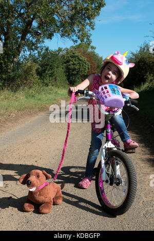 Mädchen auf dem Fahrrad mit Hund Stockfoto