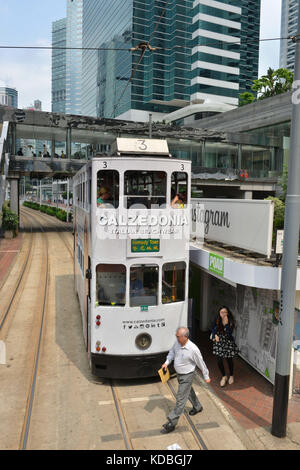 An der Unterseite der Gebäude, bunte doppelstöckigen Straßenbahn vom Hong Kong Straßenbahnen mit großen Werbung auf seinen Seiten. Calzedonia und Instagram Werbe Stockfoto