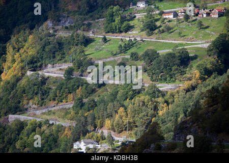 Ein ver steile Straße Zig Zags auf der Seite des Berges neben Der Geirangerfjord in Norwegen Stockfoto