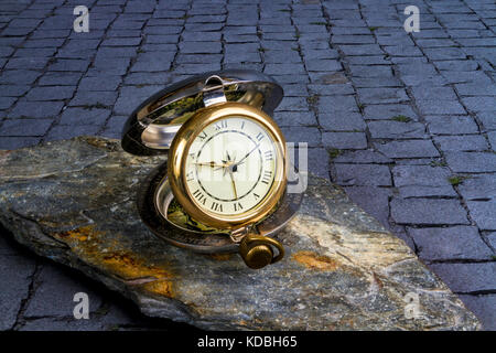 Traditionelle Wanduhr auf ein Stück Schiefer auf einem Kopfsteinpflaster Stockfoto