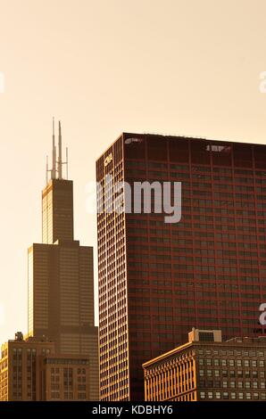 Die untergehende Sonne leuchtet auf beiden dominierenden Gebäuden in einen Teil der Skyline von Chicago, einschließlich, bei den Willis Tower, Chicago, Illinois, USA. Stockfoto