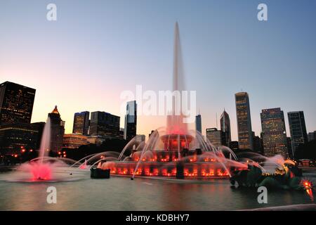 Mit einem Teil der Skyline von Chicago als Hintergrund Buckingham Fountain eine bunte Anzeige in der Dämmerung macht. Chicago, Illinois, USA. Stockfoto