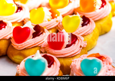 Donuts, gefüllt mit Sahne und Nachfüllen mit herzförmigen Gelee und Marmelade Stockfoto