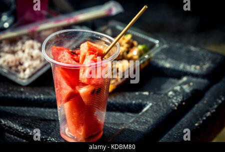 Frische Wassermelone Schicht in durchsichtigen Glas Container auf schwarzen Faser, der Pickup Truck Stockfoto