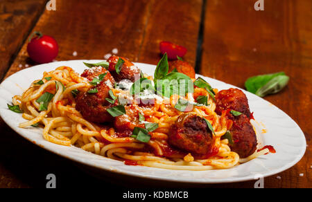 Spaghetti Nudeln mit Fleischbällchen und Tomatensauce auf hölzernen Hintergrund Stockfoto