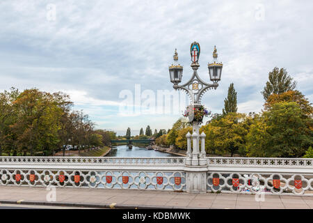 Alte twin Led leuchtet auf einem einzigen Lamp Post auf der Brücke mit weißen Geländer und kleinen roten Abdeckungen über den Fluss Ouse in York North Yorkshire England Stockfoto