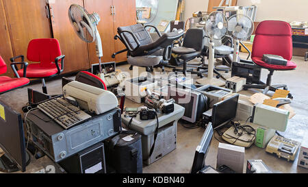 Defekte Bürostühle und elektronische Abfälle, die in der store Zimmer Stockfoto