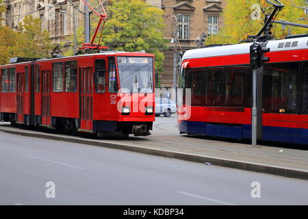 Alte rote Tatra kt4 Straßenbahn- und neuen Caf urbos 3 Straßenbahn auf den Straßen von Belgrad, Serbien Stockfoto