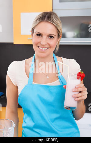 Porträt der jungen Frau mit Erdbeer Milchshake Stockfoto