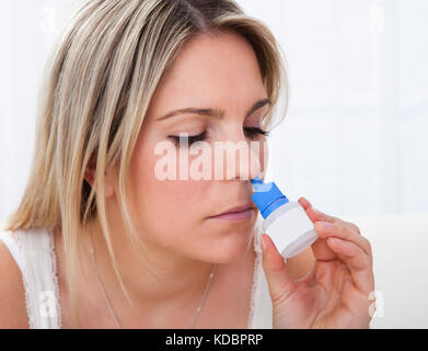 Nahaufnahme einer Frau mit Nasenspray auf weißem Hintergrund Stockfoto