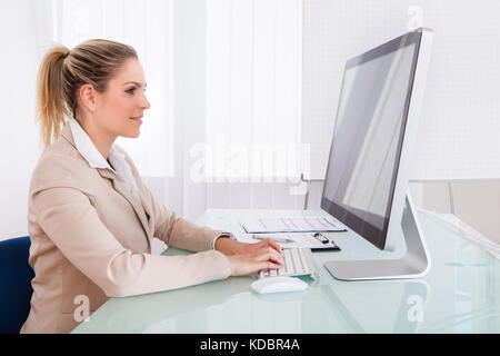 Porträt der jungen Geschäftsfrau mit Computer im Büro Stockfoto