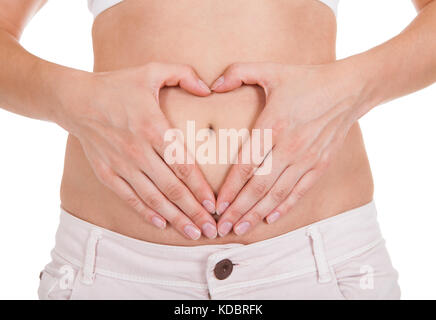 Nahaufnahme von Frauenhand bilden Herzform auf Bauch Stockfoto